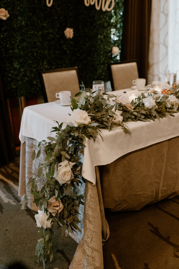 Sweetheart table with Seeded Eucalyptus greenery garland and Quicksand Roses.